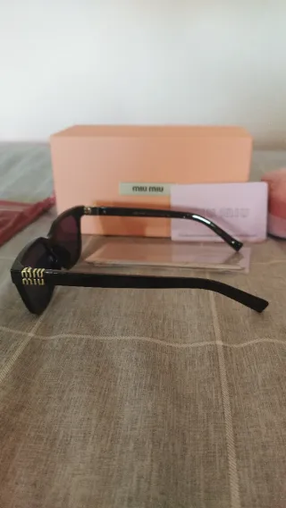 Gafas de sol Miu Miu negras y doradas mujer