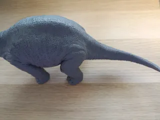 Muñeco dinosaurio gris