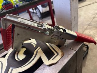 Abrazadera metálica con mordazas rojas