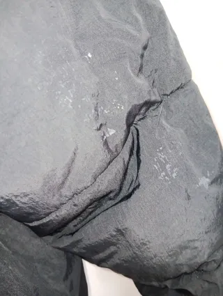 Plumas Columbia Negro tiene un defecto en la manga