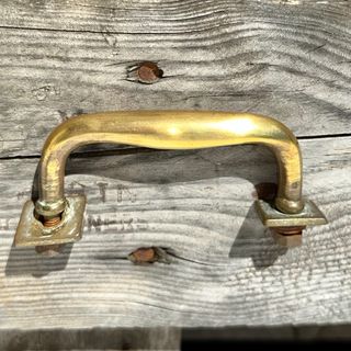 Tirador antiguo de latón con tornillos y placas