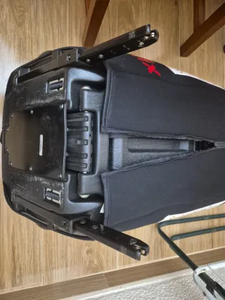 Silla de auto negra con detalles rojos con isofix.
