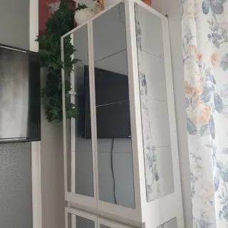 Mueble blanco y plateado con puertas de cristal