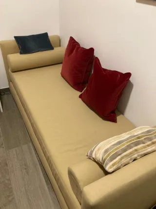 Sofá cama beige con cojines