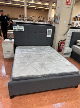 Cama tapizada gris con cabecero