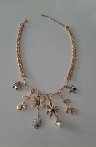 Collar dorado con dijes de flores y mariposa