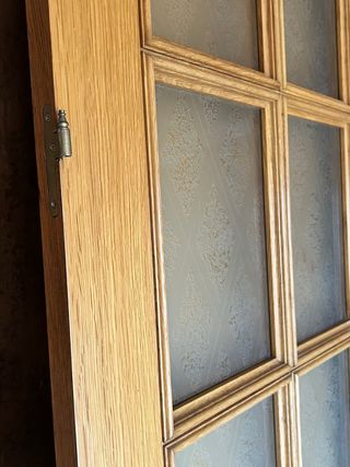 Puerta de madera con cristal y cerrojo