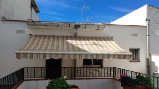 Toldo extensible beige y blanco y otro sin tela.