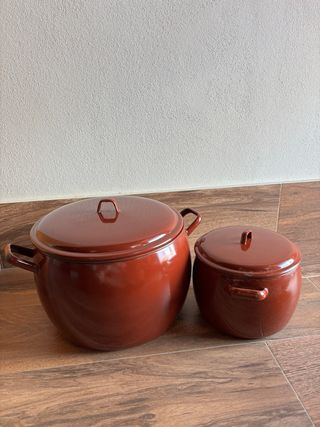 Conjunto de 2 ollas metálicas rojas con tapadera.