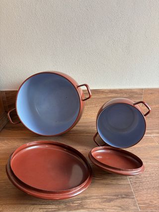 Conjunto de 2 ollas metálicas rojas con tapadera.