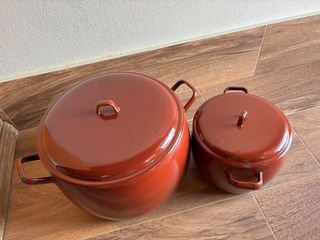 Conjunto de 2 ollas metálicas rojas con tapadera.
