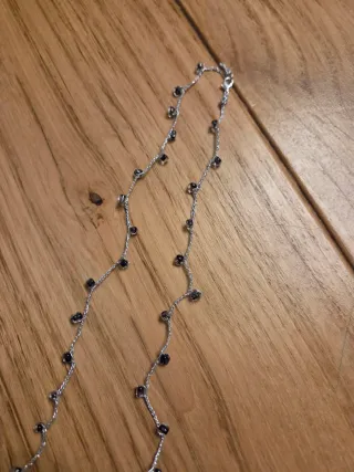 Collana con filo argentato e perline nere.