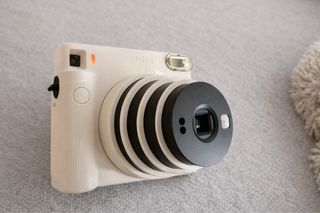Cámara instantánea Instax SQ1 + funda + 10 fotos
