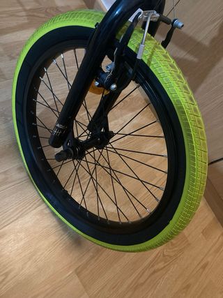 Bicicleta BMX verde con ruedas amarillas