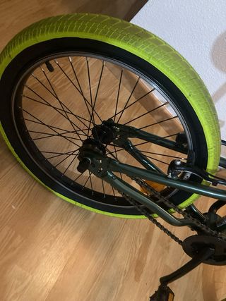 Bicicleta BMX verde con ruedas amarillas