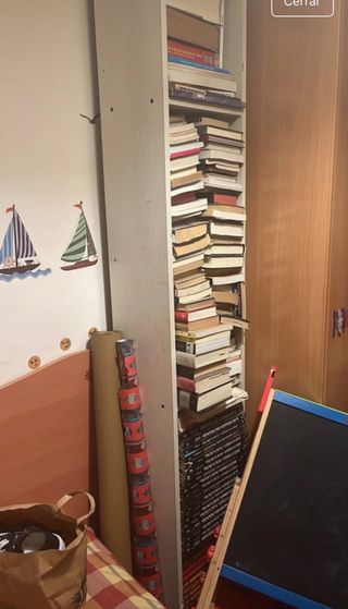 Estantería estrecha blanca con libros