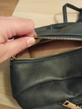 Mochila pequeña negra grisácea  y dorada