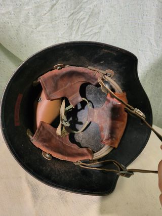 Casco militar antiguo con banda y escudo