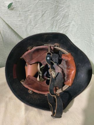 Casco militar antiguo con banda y escudo