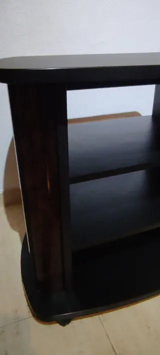 Mueble TV oscuro madera con ruedas.