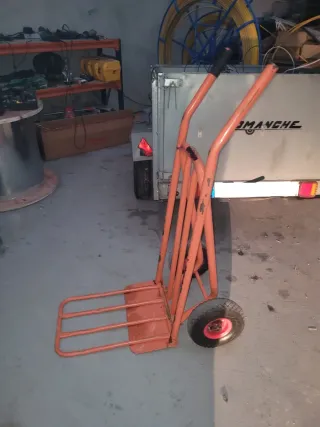 Carretilla de mano naranja con pala