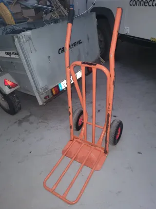 Carretilla de mano naranja con pala