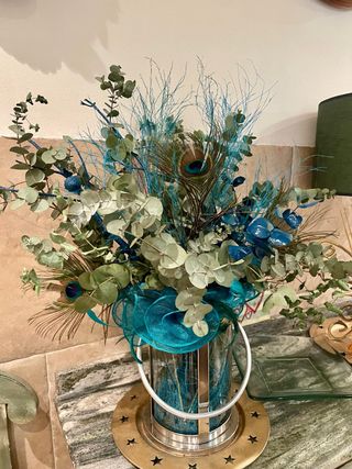 Centro de mesa flores y plumas pavo real