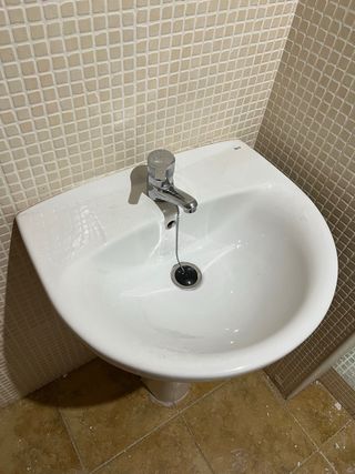 Lavabo de cerámica con grifo de metal