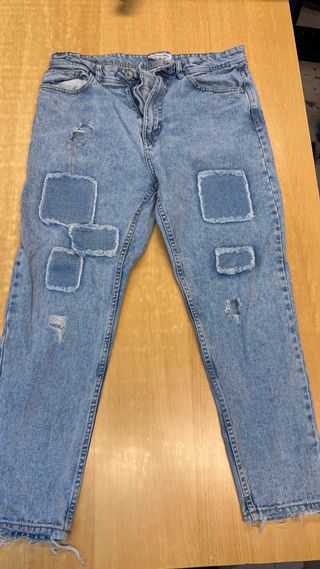 Jeans blu con toppe e strappi