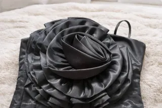 Vestido negro satinado con flor decorativa