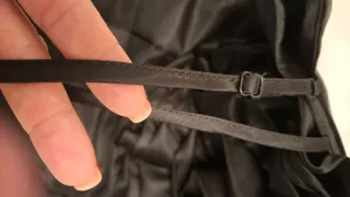 Vestido negro satinado con flor decorativa