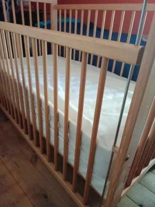 Cuna de madera con dos colchones y sabanas