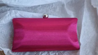 Bolso de mano fucsia.