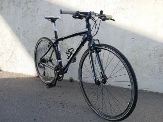 Bicicleta deportiva híbrida con manillar recto.