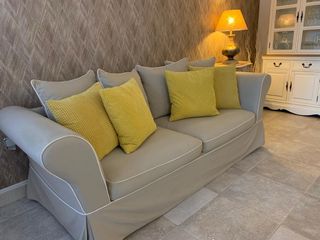 Sofá de tela beige y cojines amarillos