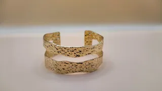 Pulsera rígida dorada de diseño exclusivo.