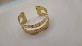 Pulsera rígida dorada de diseño exclusivo.