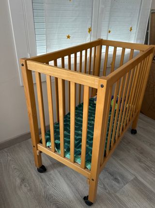Cuna de bebé de madera con ruedas
