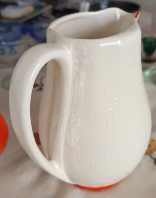 Jarra de cerámica blanca con detalles naranja