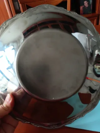 Bandeja decorativa de metal plateado.