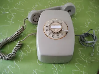 Teléfono antiguo de pared gris y blanco