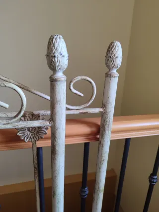 Cabecero de forja blanco con detalles.