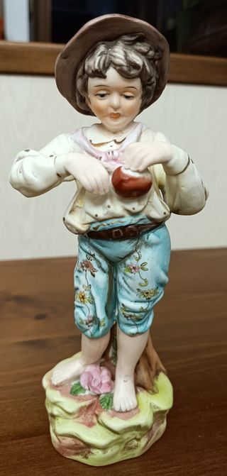 Statuina in ceramica di un bambino con cappello