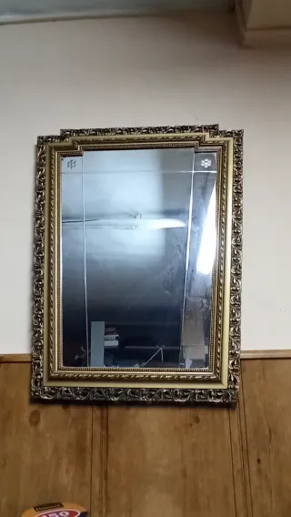 Espejo antiguo dorado con marco tallado.