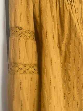 Blusa amarilla con pliegues y encaje