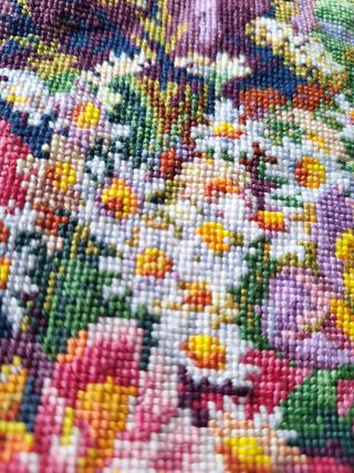 Bordado a mano de un gato mirando por la ventana