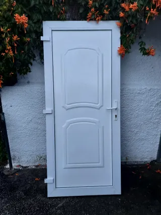 Puerta blanca exterior con marco, bombin y llabe.