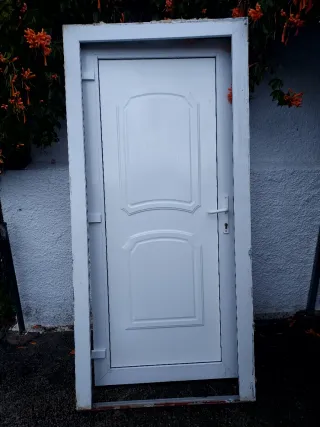 Puerta blanca exterior con marco, bombin y llabe.