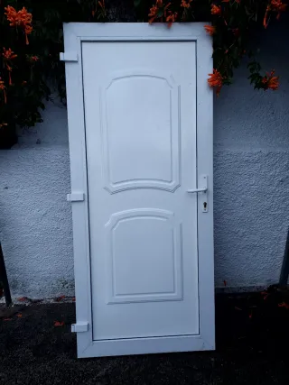 Puerta blanca exterior con marco, bombin y llabe.