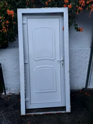 Puerta blanca exterior con marco, bombin y llabe.